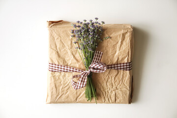 A beautiful eco-friendly gift box with a floral design, tied with a natural ribbon. The box is decorated with fresh lavender, showcasing a sustainable and nature-inspired theme