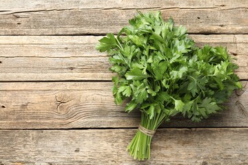 Bunch of fresh parsley on wooden table, top view. Space for text