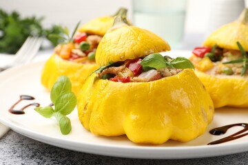 Tasty stuffed pattypan squashes on grey table, closeup