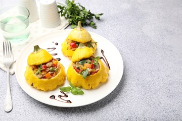Tasty stuffed pattypan squashes served on grey table. Space for text