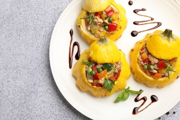 Tasty stuffed pattypan squashes on grey table, top view