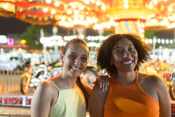 Two friends enjoying a vibrant night at the carnival