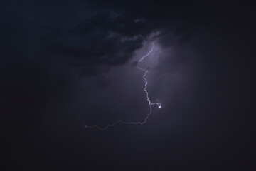 Dark, dramatic storm clouds gather on the horizon, hinting at an approaching thunderstorm. The sky...