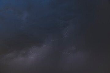 Dark, dramatic storm clouds gather on the horizon, hinting at an approaching thunderstorm. The sky...