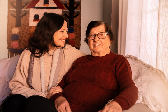 filha adulta olhando para m&atilde;e idosa com admira&ccedil;&atilde;o e amor