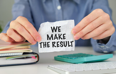 A person holding a piece of paper that says We Make the Result.
