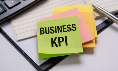 A yellow, green and orange sticky note with the word Business KPI on it.