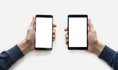 Hands hold identical tablets with white screens against plain gray background. High-angle perspective captures hands from below. Two hands, identical tablets, technology, mobile device, touch screen,