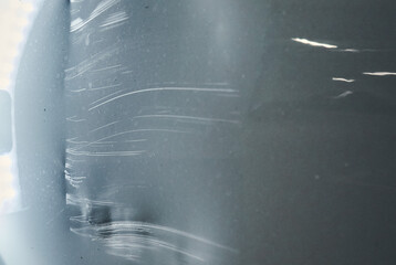 Scratched Surface on a Dark Car Body Reflecting Light in a Garage Setting