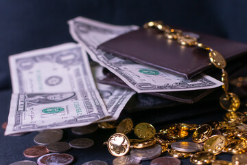 Several one dollar bills surrounding a brown leather wallet. The photograph is styled with gold...