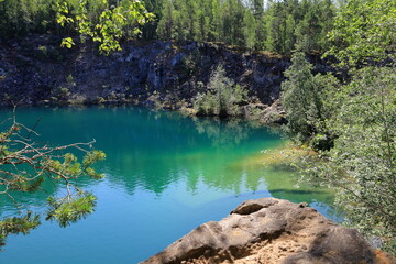 Limestone quarry lake with turquoise water. Summer day in Uskavi, Nora, Bergslagen, Sweden.