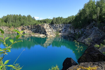 Limestone quarry lake with turquoise water. Summer day in Uskavi, Nora, Bergslagen, Sweden.