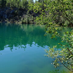 Limestone quarry lake with turquoise water. Summer day in Uskavi, Nora, Bergslagen, Sweden.