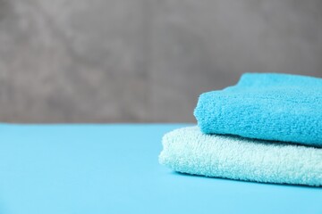 Soft towels on light blue table, closeup. Space for text