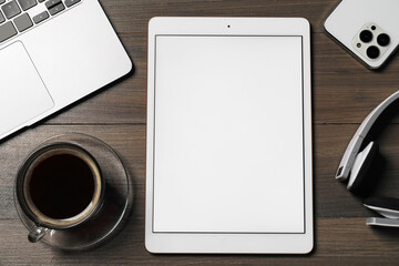 Tablet, smartphone, headphones, coffee and laptop on wooden table, flat lay