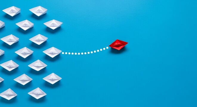 Red paper boat leading others symbolizing leadership, innovation, and business strategy on blue background