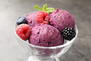 Delicious sorbet with fresh berries and mint in dessert bowl on grey textured table, closeup