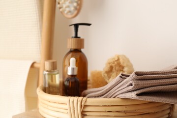 Clean waffle towels and spa products near white wall, closeup