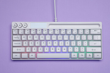 White keyboard with RGB lighting on violet background, top view