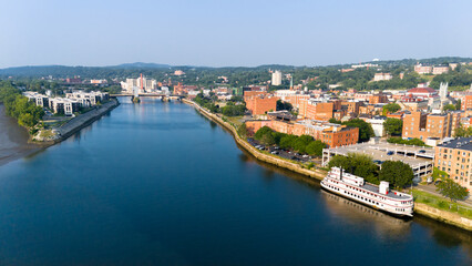 Aerial view of historic downtown Troy, NY, at sunset with docked riverboat and view north along the...