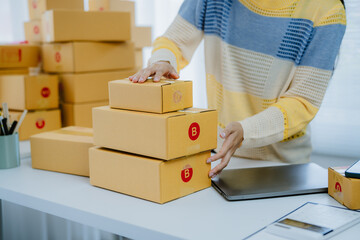 Young woman small business owner online shopping at home. checking orders from customers with...