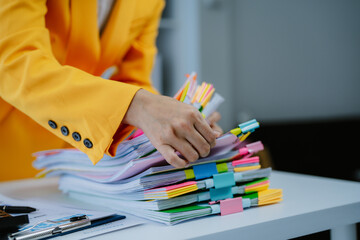 Business Documents, Business woman working in Stacks of paper files for searching and checking...