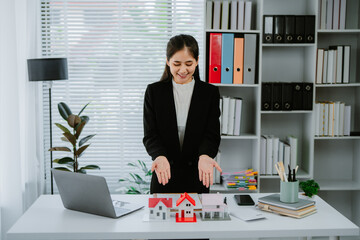 Female woman hand holding home model, investment small miniature white toy house. Mortgage property...