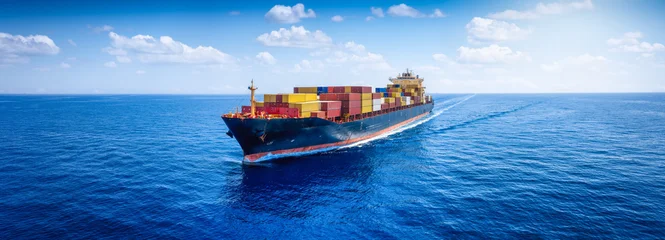 Fototapete Rund Segeln Panoramic aerial view of a loaded container cargo carrier ship sailing over the open ocean as a banner for transport and industry  © moofushi