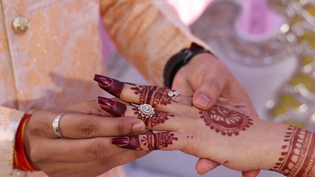 oyous moment from an Indian ring ceremony where the bride and groom exchange rings as part of their engagement celebration