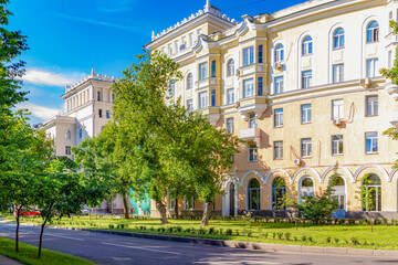 Sunny Moscow street in Shchukino district with 1950s Stalinist-era residential buildings surrounded...