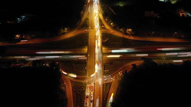 A busy highway with a lot of traffic. The traffic is moving in different directions. There are many cars and trucks on the road. Aerial night view Larkin
