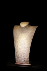 Bust for jewelry on black background, spot lighting. Showcase for jewelry display, in luxury...