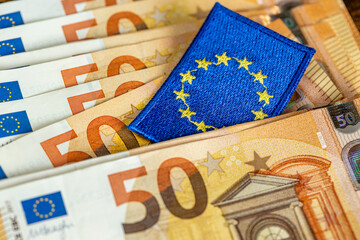 The European Union symbol between euro banknotes. Financial business concept, investment background, Eurozone analysis