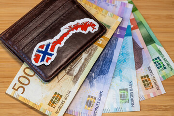 Norway money. A wallet with the Norwegian flag and Norwegian paper banknotes NOK krone, lying on the table. Financial business concept. Close-up