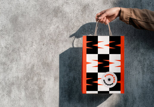Paper Bag Mockup with Held Against Concrete Wall