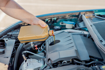 Pouring engine oil into a car engine