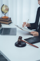 Justice in Session: A legal professional meticulously reviews documents while the symbolic gavel of...