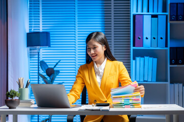 Focused Professional: A vibrant businesswoman, immersed in her work, engaging with her laptop and...