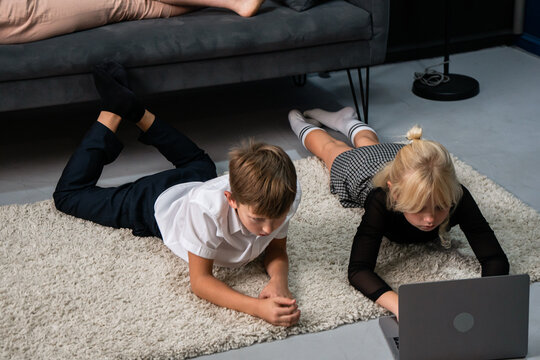 Children Laptop Home - Two kids using a laptop on the floor in a home setting. - Powered by Adobe