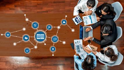 A diverse team engages in a business meeting focused on data analysis related to advertising,...