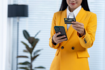 Digital Shopping: A businesswoman is focused on online shopping through smartphone with a credit...