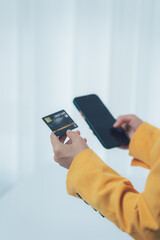 Digital Transaction: An individual gracefully interacts with a smartphone, complemented by a sleek credit card, symbolizing secure digital transactions and convenient modern financial practices.