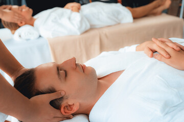 Caucasian couple enjoying relaxing anti-stress head massage and pampering facial beauty skin...