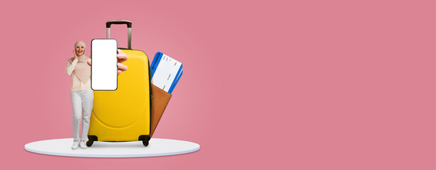 A traveler stands beside a bright yellow suitcase, holding a smartphone displaying a blank screen....