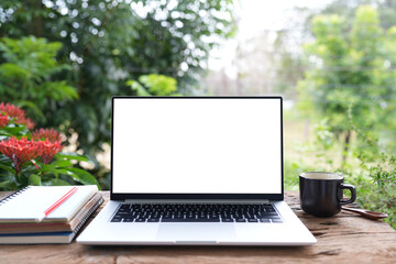 Laptop and notebook, black coffee cup, working in the garden