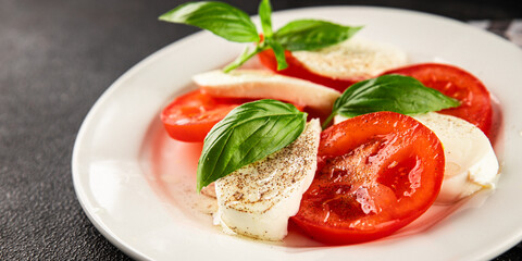 Caprese salad mozzarella and tomato, basil fresh delicious gourmet food background on the table rustic food top view copy space keto and paleo diet vegan and vegan food
