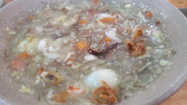Thick soup with egg and seafood, national Vietnamese cuisine. Street food in small restaurant, local cuisine