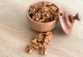 Walnuts kernels on dark desk with color background, Whole walnut in wood vintage bowl.