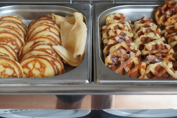 Assortment of Danish pastries and sweet rolls displayed at hotel breakfast buffet.