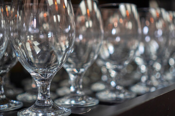 Clean wine glasses aligned neatly on a wooden bar counter for service.